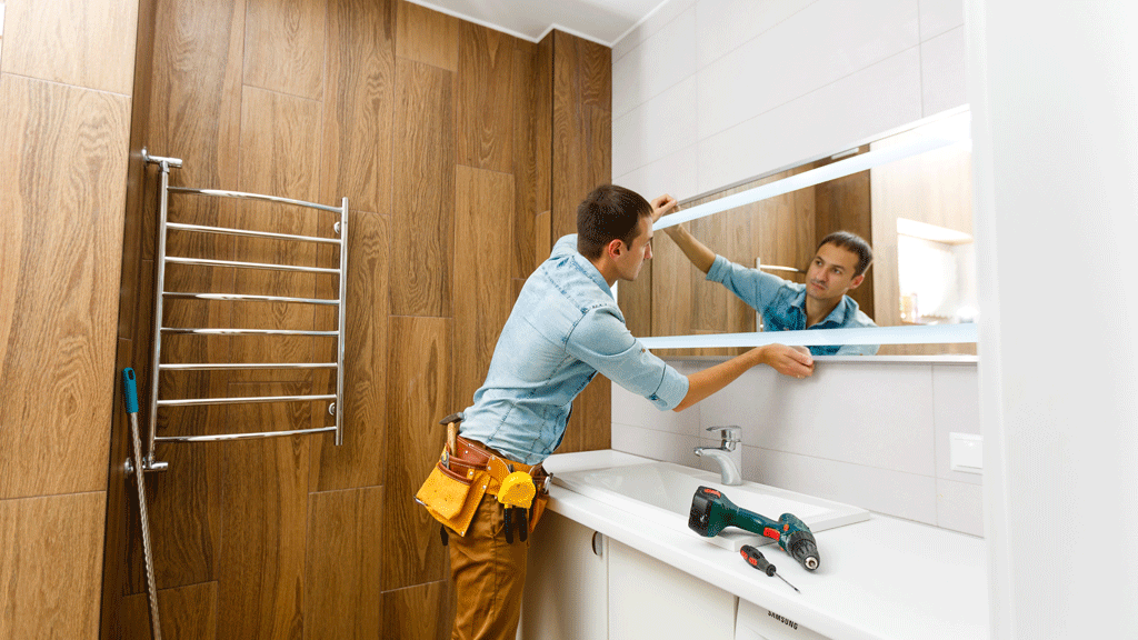 Artisan carreleur posant du carrelage dans une salle de bain en rénovation, chantier en cours