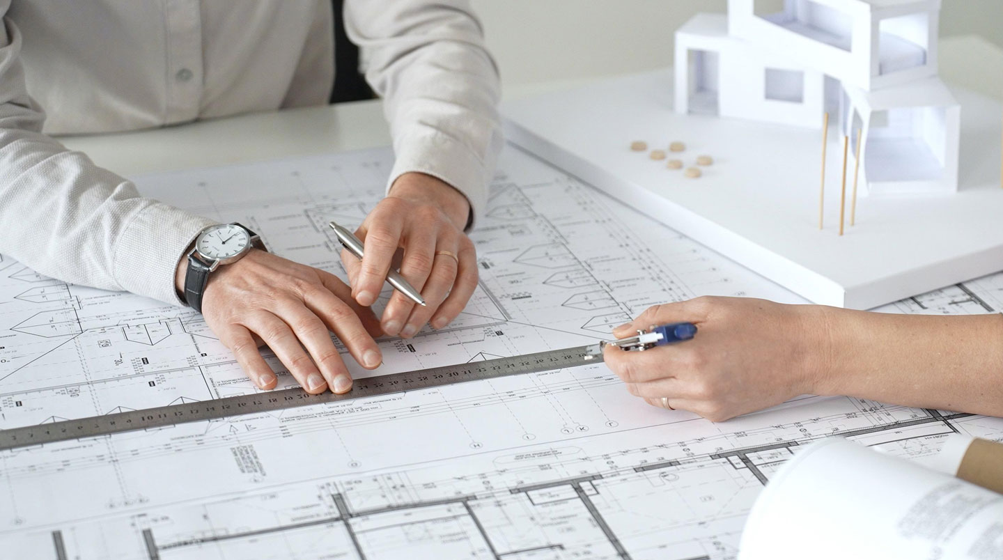 Plans d'extension et échantillons de matériaux disposés sur une table de travail de chantier